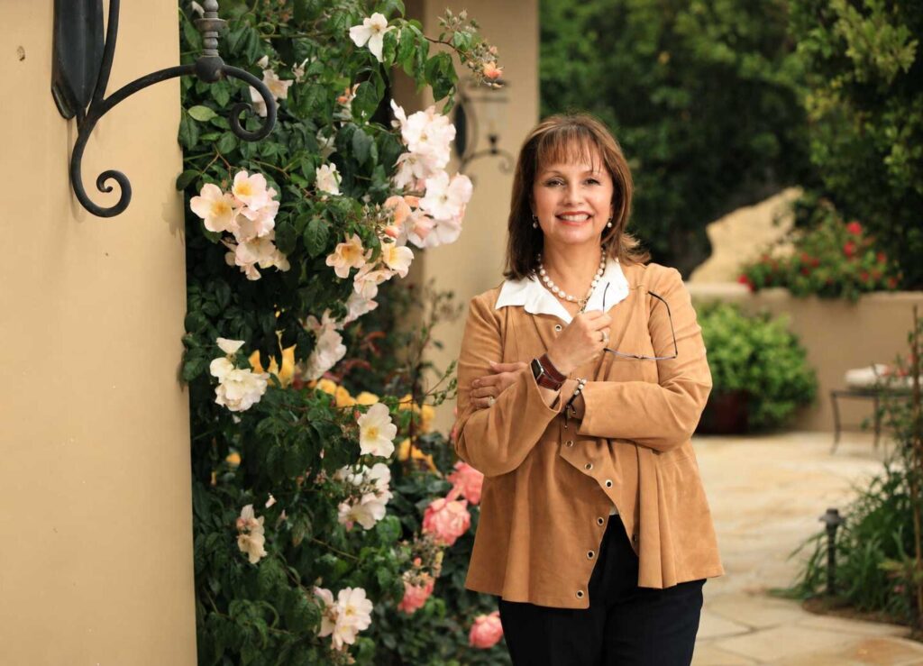 exec coach carmie saldana standing near flowers